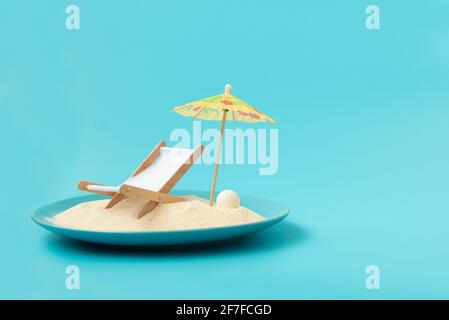 Plage tropicale concept fait de plaque avec sable, chaise de pont et parasol. Concept de vacances d'été créatif Banque D'Images