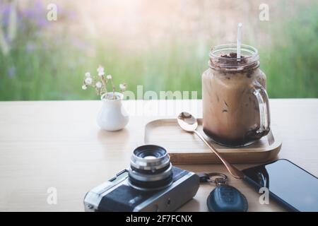 Café glacé, téléphone intelligent avec clé et appareil photo dans le café Banque D'Images