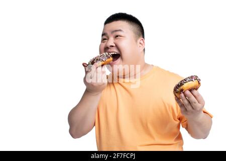 Young man eating donut Banque D'Images