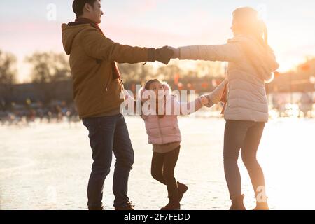 Bonne famille jouant sur la glace Banque D'Images