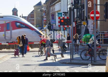 Lincoln High Street Level Crossing avec des barrières vers le bas et des piétons attendant. PASSAGE du train LNER. De Lincoln à Londres Banque D'Images