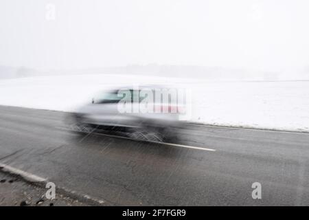 Tutzing, Allemagne. 07e avril 2021. Une voiture roule sur une route de campagne près de Tutzing dans une légère neige. Par temps froid, les routes en difficulté sont facilement praticables malgré la neige. Credit: Felix Hörhager/dpa/Alay Live News Banque D'Images