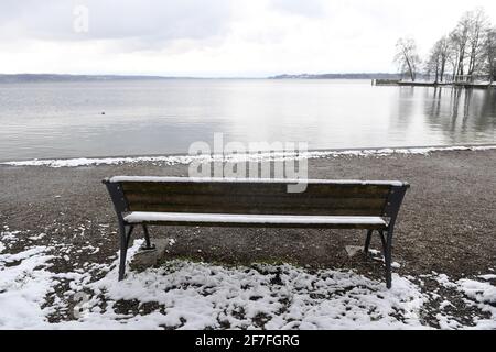 Tutzing, Allemagne. 07e avril 2021. La neige se trouve à côté d'un banc de parc près de la Dampfersteg Tutzing au Starnberger See à des températures froides. Credit: Felix Hörhager/dpa/Alay Live News Banque D'Images