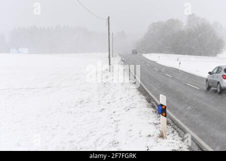 Tutzing, Allemagne. 07e avril 2021. Les voitures circulent sur une route de campagne près de Tutzing dans une neige légère. Par temps froid, les routes en difficulté sont facilement praticables malgré la neige. Credit: Felix Hörhager/dpa/Alay Live News Banque D'Images