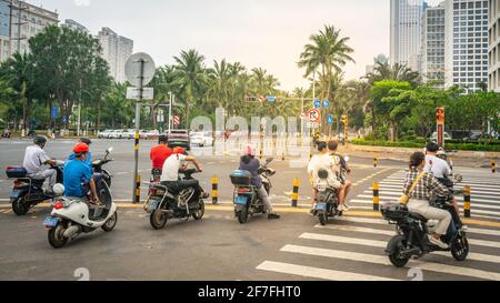 Haikou Chine , 21 mars 2021 : personnes en scooter dans la rue de Haikou moderne en Chine Hainan Banque D'Images