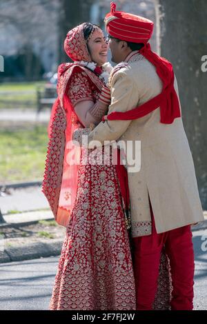 Un couple hindou en vêtements ethniques très ornés pose pour des photos avant mariage dans un parc à Queens, New York. Banque D'Images