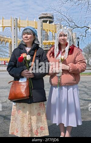 Une mère et une fille prient à un service de plein air sur le site du pavillon du Vatican '64 World's Fair. À Flushing Meadows Corona Park, Queens, NY. Banque D'Images