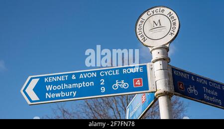 Berkshire, Angleterre, Royaume-Uni. 2021. Réseau national de vélo et autres panneaux le long de la route du canal Kennet et Avon contre un ciel bleu. Banque D'Images