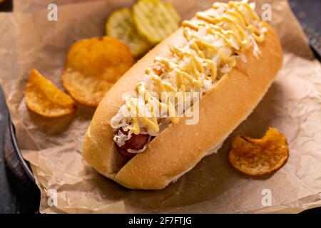 Hot dog avec choucroute et moutarde sur parchemin Banque D'Images