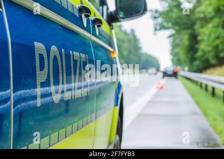 Voiture de police sur l'autoroute dans une perspective latérale lors d'un accident. Police lettrage sur le corps avec le bras et le fond jaune. Épaule dure, voie Banque D'Images