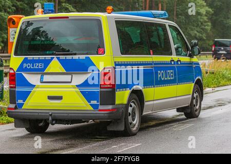 Voiture de police allemande dans un arrêt d'urgence sur l'autoroute à côté d'un téléphone d'urgence. Temps pluvieux et surface de route humide. Vue de la carrosserie du véhicule Banque D'Images