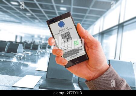 Téléphone portable en main avec certificat numérique vert de vaccination covid-19. Écran de téléphone cellulaire avec des informations sur la vaccination et les anticorps contre le covi Banque D'Images