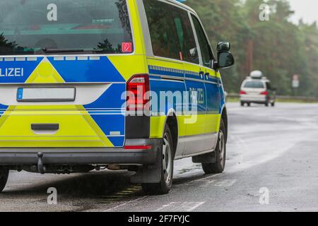 Vue partielle d'une voiture de police allemande sur l'autoroute par temps pluvieux. Côté passager du véhicule avec le lettrage police sur la carrosserie en bleu Banque D'Images