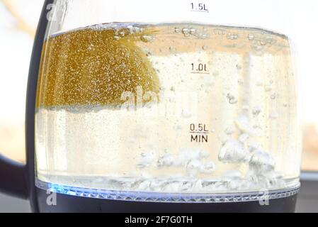 Un demi-citron jaune est bouilli dans un verre électrique bouilloire pour le détartrage Banque D'Images