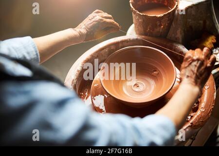 Femme senior mains de fabrication de bol en argile dans l'atelier de poterie Banque D'Images