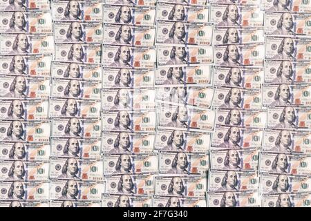 Une centaine de dollars s'accumulent en arrière-plan. Beaucoup de billets de papier de dollars américains en arrière-plan. Banque D'Images