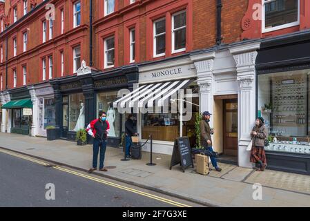 La boutique de robes de mariée Bridal Rogue Gallery et le café Monocle. Quatre personnes se trouvent dans la rue à l'extérieur du café. Chiltern Street, Londres, Angleterre, Royaume-Uni Banque D'Images