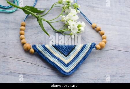 Accessoires faits main dans un style ethnique et de fleurs sur table en bois. Les choses faites maison au crochet. Crochet pattern. Fabrication artisanale. Banque D'Images