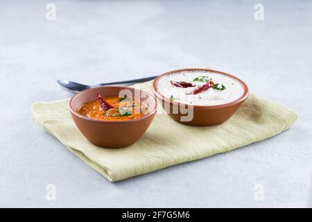 Chutney chutney de noix de coco blanc et chutney d'oignons disposés dans une serviette placée sur un fond texturé gris. Banque D'Images