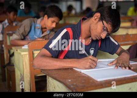 Varanasi, Inde. 10-16-2019. Groupe d'élèves écrivant dans leurs manuels tout en faisant leurs devoirs avant de dîner dans les locaux de l'école. Banque D'Images