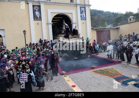 Des hommes bien habillés en costume et des femmes en tenue traditionnelle participent à la procession solennelle Semana Santa à Antigua, au Guatemala. Banque D'Images