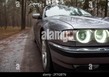 Chernigov, Ukraine - 6 janvier 2021: Ancienne voiture BMW série 7 (E38) sur la route dans la forêt. Temps sombre Banque D'Images