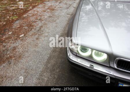 Chernigov, Ukraine - 6 janvier 2021: Ancienne voiture BMW série 7 (E38) sur la route dans la forêt. Temps sombre Banque D'Images