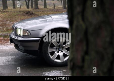 Chernigov, Ukraine - 6 janvier 2021: Ancienne voiture BMW série 7 (E38) sur la route dans la forêt. Temps sombre Banque D'Images