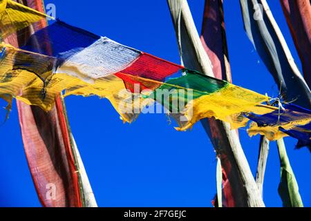 Drapeaux de prière dans l'Himalaya, Royaume du Bhoutan Asie ciel bleu flutter dans le vent tissu matériel coloré Banque D'Images