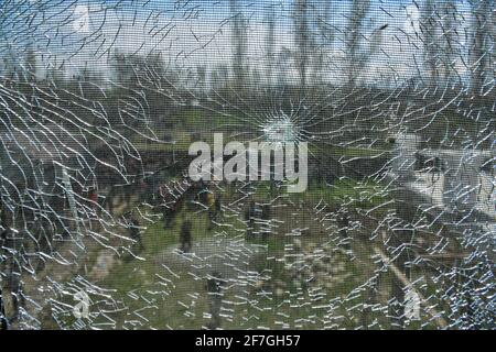 Un trou de balle est visible sur une fenêtre de maison endommagée lors d'une opération anti-militance à la périphérie de Srinagar. Une opération de recherche de dix-sept heures a été lancée mardi soir dans la région de Gulab Bagh, à Srinagar, et a été lancée mercredi après qu'aucun militant n'ait été trouvé dans la région. L'agence de presse locale KDC a rapporté que les forces de sécurité ont tiré quelques coups de feu vers le bâtiment dans lequel elles soupçonnaient la présence de militants. Cependant, il n'y a pas eu de réponse de l'intérieur de la maison, l'opération a été mise hors service. Banque D'Images