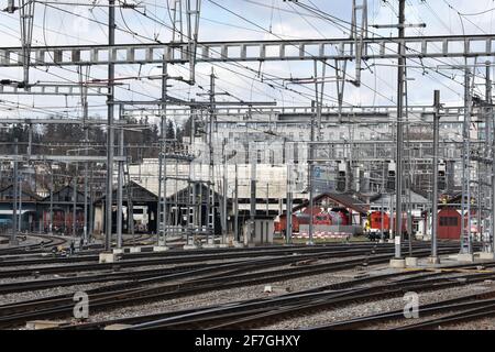 Dépôt ferroviaire avec des trains garés à Winterthur, en Suisse, avec beaucoup de piliers électriques ferroviaires et de lignes électriques. Banque D'Images