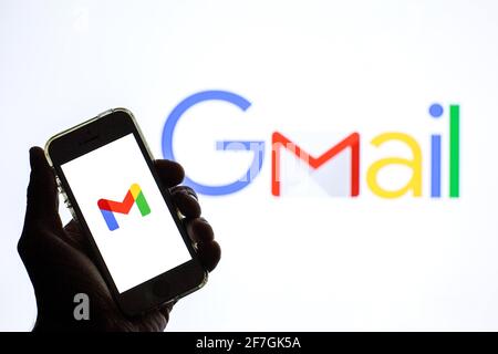 Dans cette illustration, l'application Google Gmail affichée sur l'écran d'un smartphone et le logo Google Gmail en arrière-plan. Banque D'Images