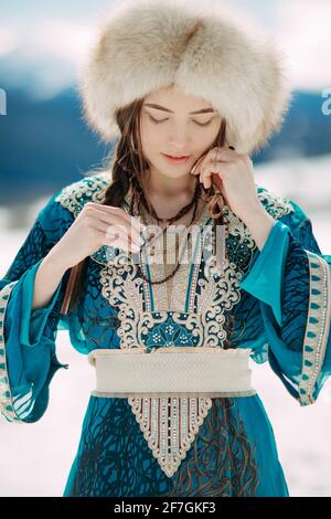 Portrait d'une jeune femme vêtue de robe brodée et d'un chapeau de fourrure. Banque D'Images