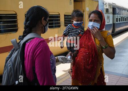 Un professionnel de la santé vérifie le niveau d'oxygène d'une femme à son arrivée en train à Dadar Terminus.les passagers arrivant dans les trains à destination de Mumbai depuis l'État du Gujarat sont soumis à un contrôle du niveau d'oxygène, la température et, s'il s'avère souffrir de fièvre, doivent subir des tests par écouvillonnage à la gare ferroviaire avant d'être autorisés à se rendre à leur destination respective. Banque D'Images