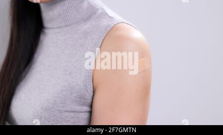 Jeune femme vaccinée avec un bracelet-secours sur son bras Banque D'Images