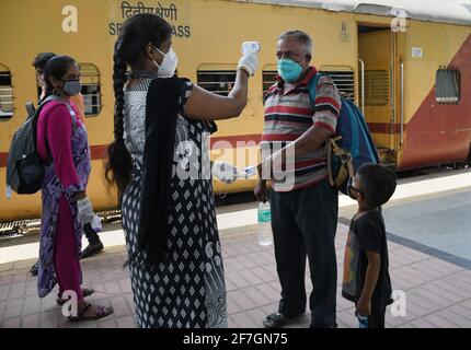 Mumbai, Inde. 07e avril 2021. Un professionnel de la santé filtre un homme pour la température et le niveau d'oxygène à l'arrivée en train à Dadar Terminus.les passagers arrivant dans les trains à Mumbai de l'état de Gujarat sont contrôlés pour le niveau d'oxygène, la température et, s'il s'avère souffrir de fièvre, doivent subir des tests par écouvillonnage à la gare ferroviaire avant d'être autorisés à se rendre à leur destination respective. (Photo par Ashish Vaishnav/SOPA Images/Sipa USA) crédit: SIPA USA/Alay Live News Banque D'Images