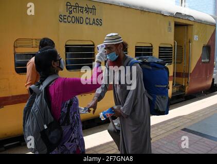 Mumbai, Inde. 07e avril 2021. Un professionnel de la santé filtre un passager pour la température et le niveau d'oxygène à son arrivée en train à Dadar Terminus.les passagers arrivant dans les trains à Mumbai de l'état de Gujarat sont contrôlés pour le niveau d'oxygène, la température et, s'il s'avère souffrir de fièvre, doivent subir des tests par écouvillonnage à la gare ferroviaire avant d'être autorisés à se rendre à leur destination respective. (Photo par Ashish Vaishnav/SOPA Images/Sipa USA) crédit: SIPA USA/Alay Live News Banque D'Images