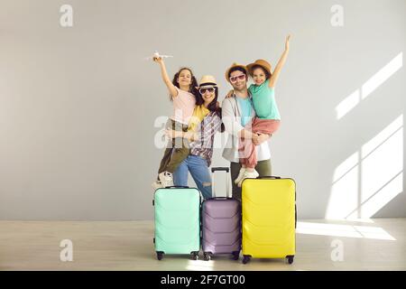 Portrait de touriste en famille heureux prêt pour le voyage posant à l'appareil photo avec valise Banque D'Images