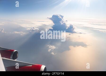 Photo de la fenêtre de l'avion. Deux moteurs et nuages. Un beau nuage et les rayons du soleil à travers lui Banque D'Images