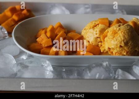 Des boules de glace à la mangue maison servies avec des mangues fraîches coupées de Lalbagh. Un régal dans la chaleur estivale. Banque D'Images