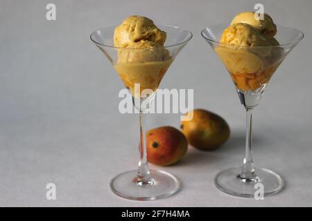 Des boules de glace à la mangue maison servies dans un verre à cocktail avec des mangues fraîches de Lalbagh. Un régal dans la chaleur estivale. Banque D'Images