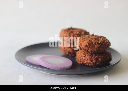 Escalope de poulet brun foncé. Friture homogène pour une texture croustillante. Prise de vue sur fond blanc Banque D'Images