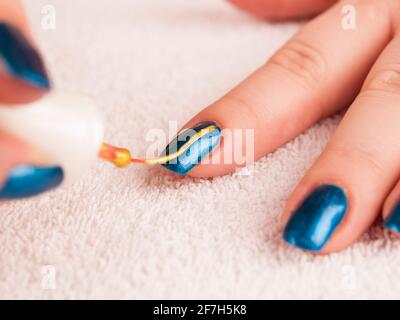 Peinture nail art moderne avec de l'or vernis base bleu Banque D'Images