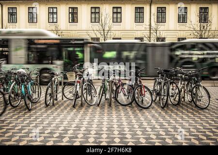 Les vélos utilisés pour les déplacements sont garés dans une rue de la ville, avec un bus urbain visible en arrière-plan. Concept de véhicule de transport urbain Banque D'Images