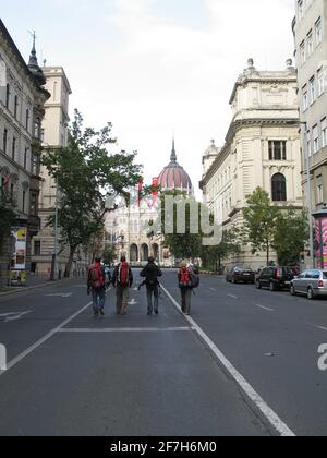 Bâtiment du Parlement à Budapest, en hongrie, avec quatre routards qui marchent vers lui sur la route. Banque D'Images