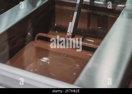 Agitation industrielle de chocolat. Les machines de l'usine de chocolat incorporent le mélange de chocolat dans des récipients en acier inoxydable. Banque D'Images