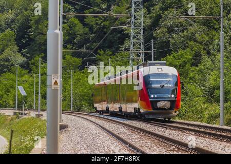 Plusieurs unités électriques modernes s'entraînent sur une voie ouverte. Train de banlieue se précipitant vers la ville dans un environnement rural par une journée ensoleillée. Banque D'Images