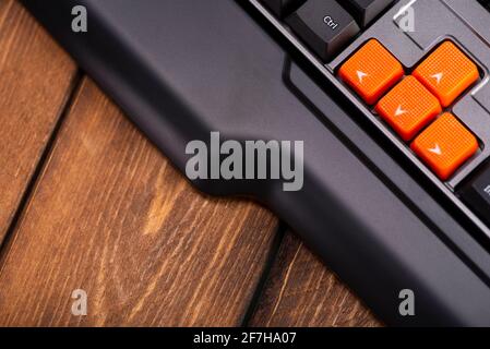 Touches fléchées orange sur un clavier noir, touches haut, bas, gauche, droite sur un clavier d'ordinateur de jeu. Banque D'Images