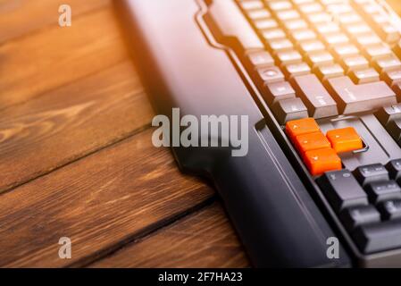 Touches fléchées orange sur un clavier noir, touches haut, bas, gauche, droite sur un clavier d'ordinateur de jeu. Banque D'Images