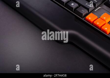 Touches fléchées orange sur un clavier noir, touches haut, bas, gauche, droite sur un clavier d'ordinateur de jeu. Banque D'Images